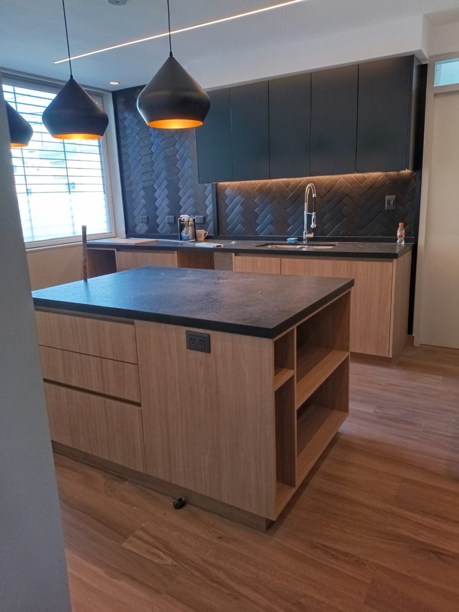 Cocina moderna con isla de madera y detalles en negro — proyecto Belgrano, por Licefe Carpentry SRL, en Belgrano